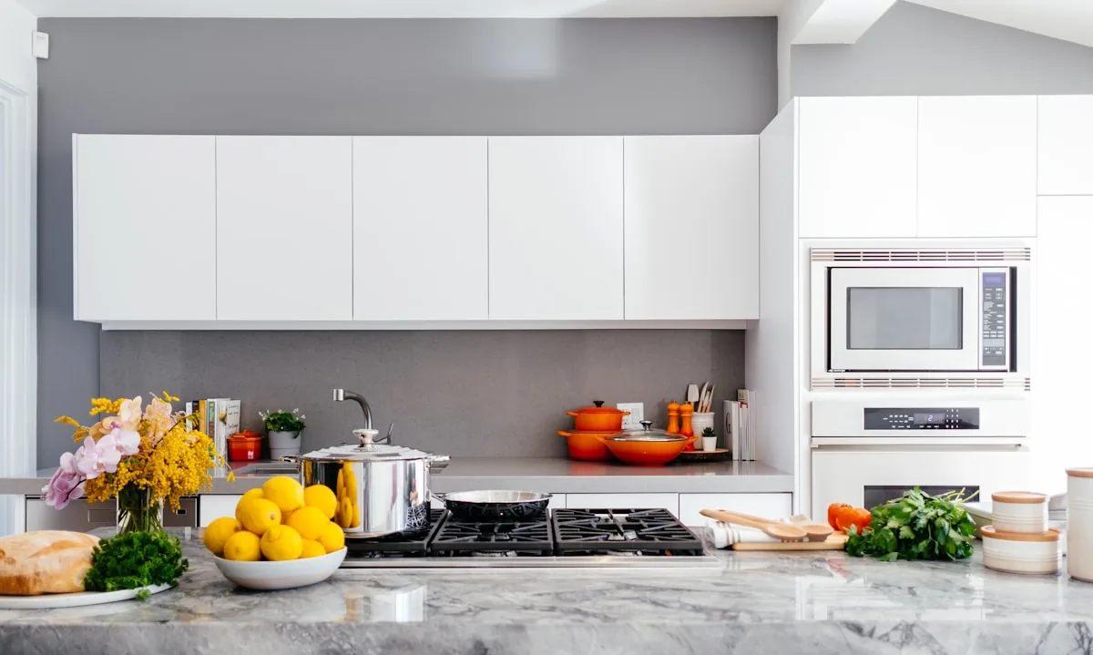 Illustrative kitchen interior with white cabinets and stone countertops